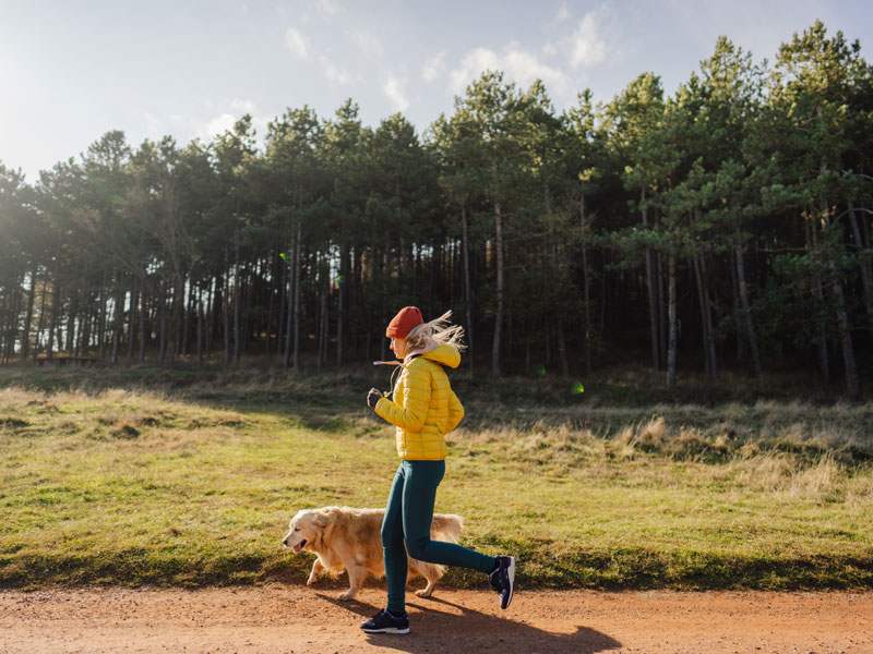 person running with dog outside