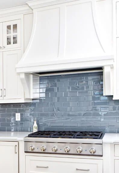 Grey-black-bricked backsplash against cream-colored kitchen