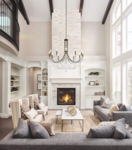 Vaulted ceiling in furnished living room with chandelier and fireplace