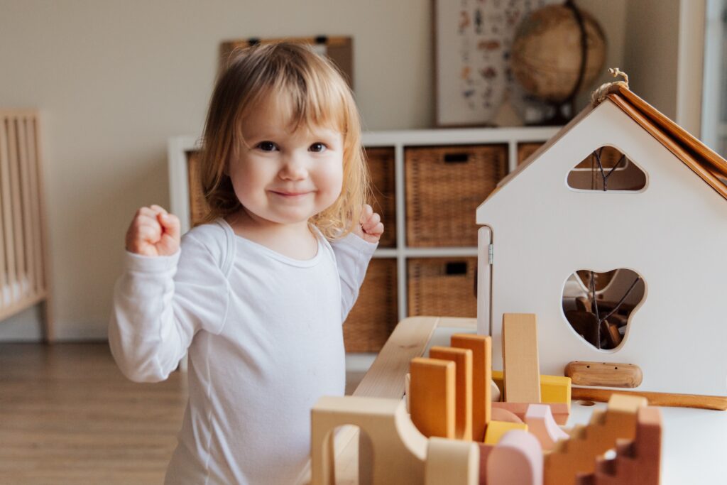 An attic playroom with a smiling child looking at the camera