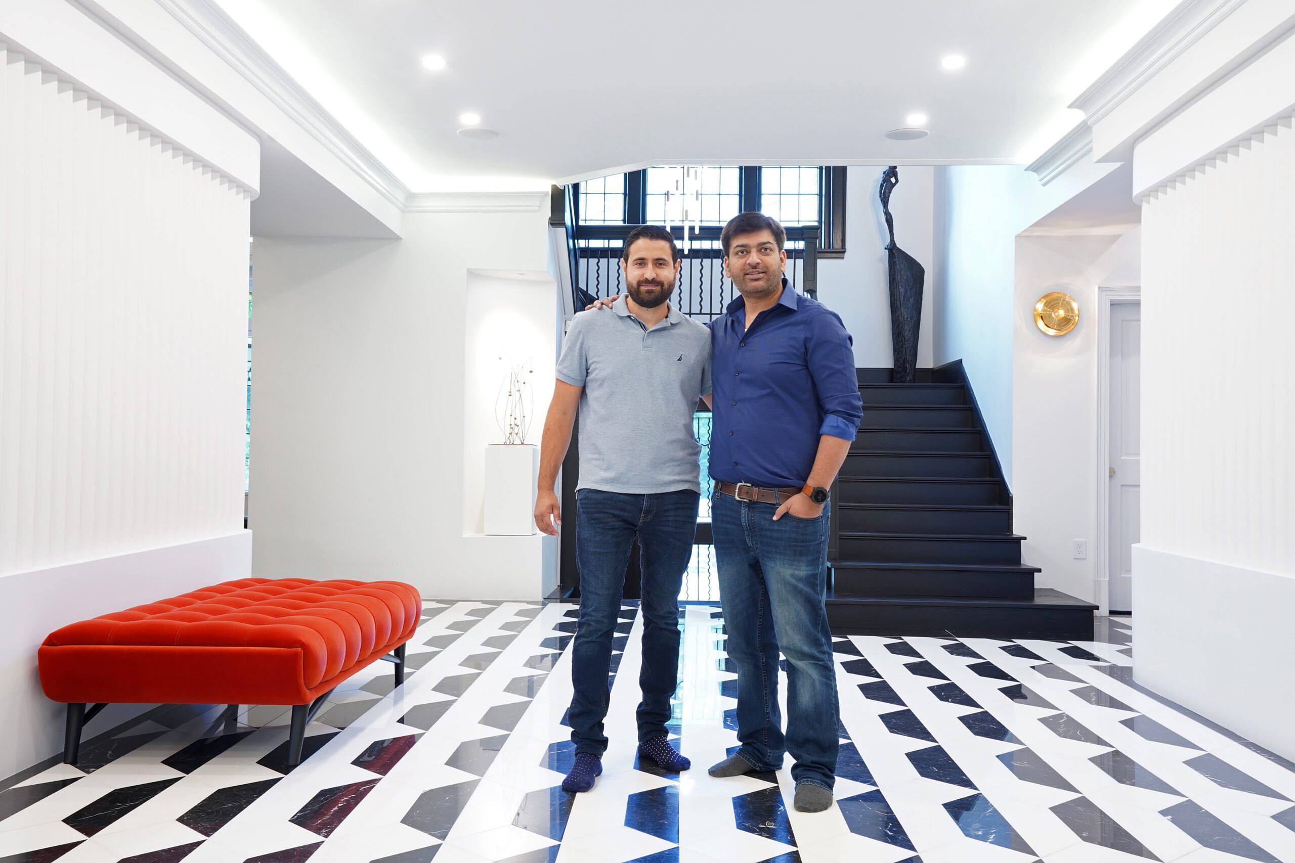 Hasnain and team smiling in the entrance of a home