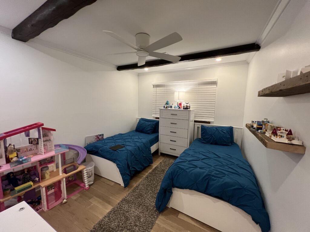 A child's bedroom with twin beds and blue blankets