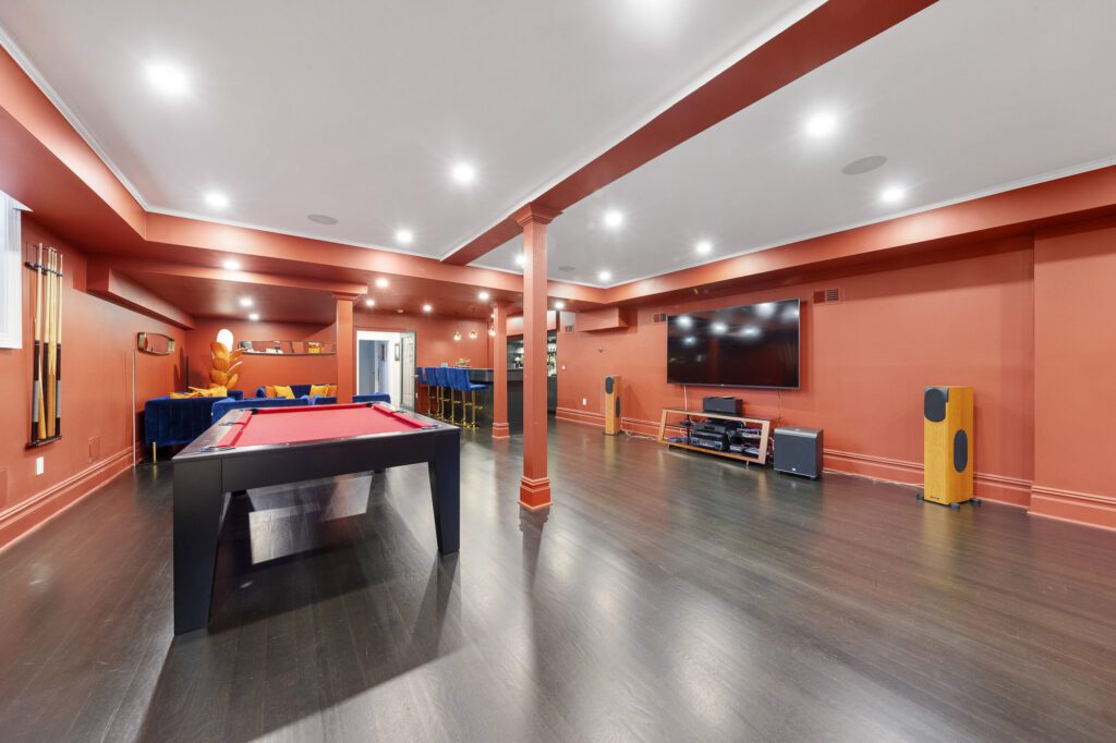 Entertainment room with bold red colors, a pool table, a big screen TV, and a mini-bar