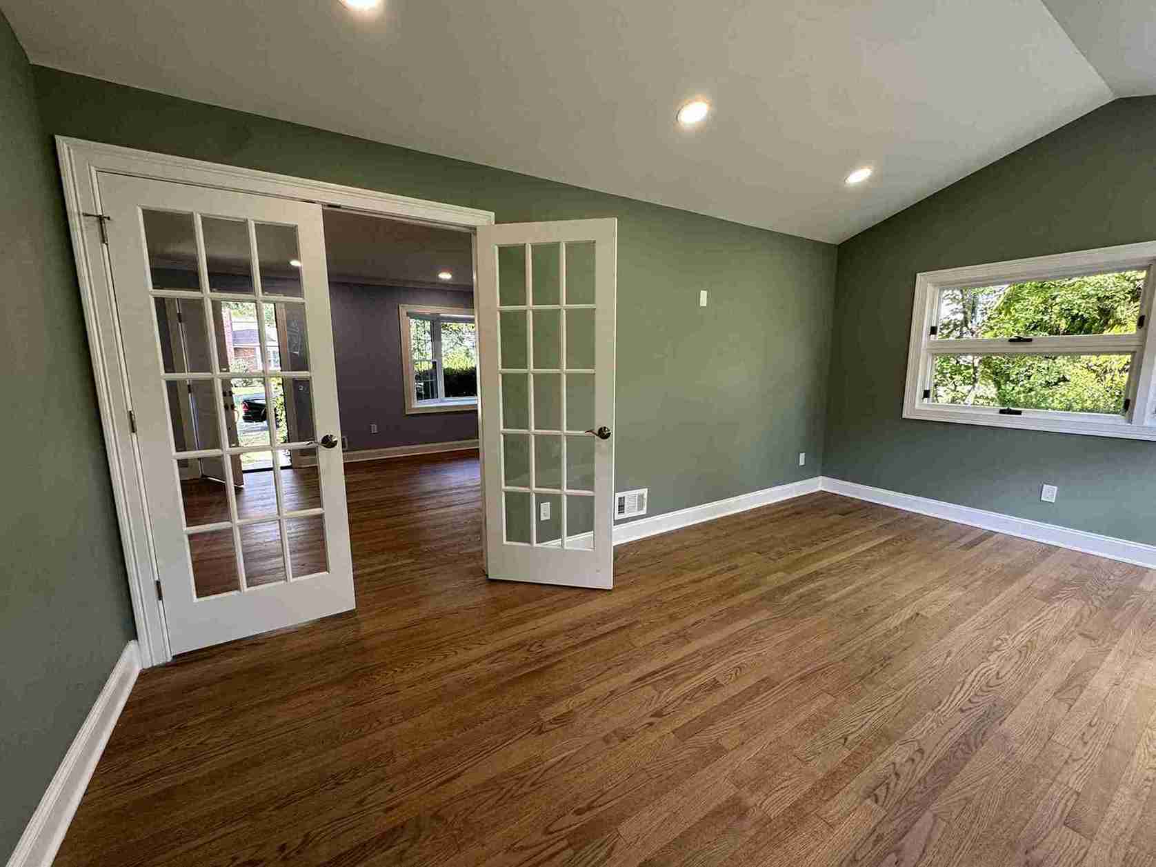 Spacious family room upgrade featuring modern fireplace, built-in shelves, ample natural light and hardwood flooring.