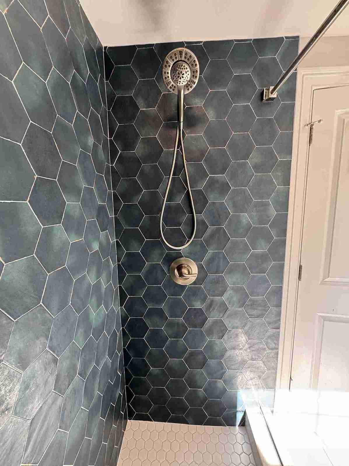 Exterior curb appeal upgrade featuring new siding, stone accent wall, refreshed landscaping, and modern garage door design