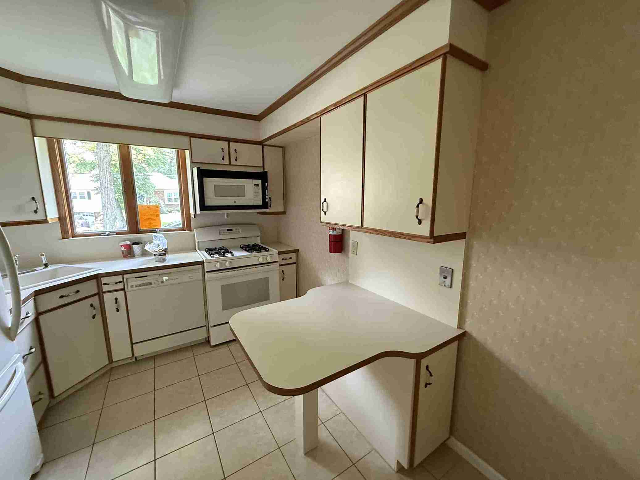 New sunroom addition in Bergenfield home featuring vaulted ceiling, multiple windows, fresh hardwood floor and green wall