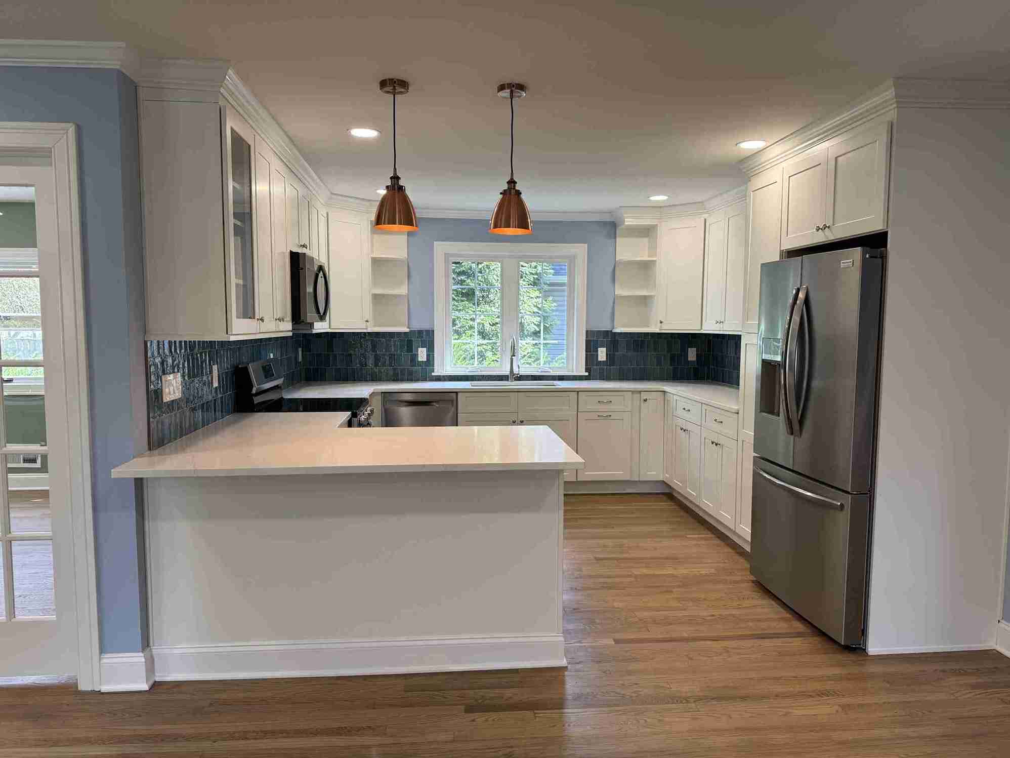 Elegant living-room renovation featuring new hardwood floors, recessed lighting, and large windows for natural light