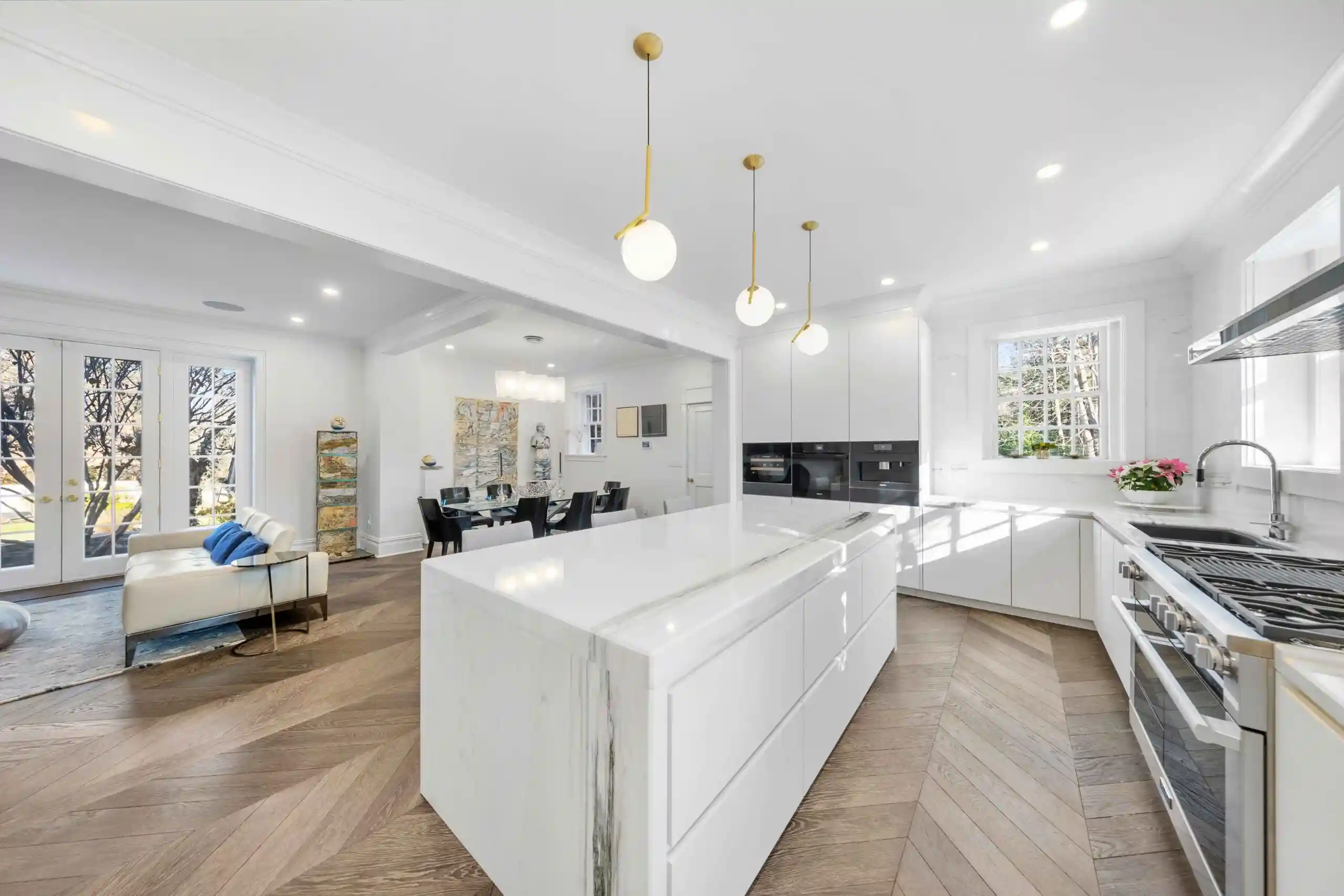 A modern kitchen featuring white cabinets and a spacious central island for cooking and dining.