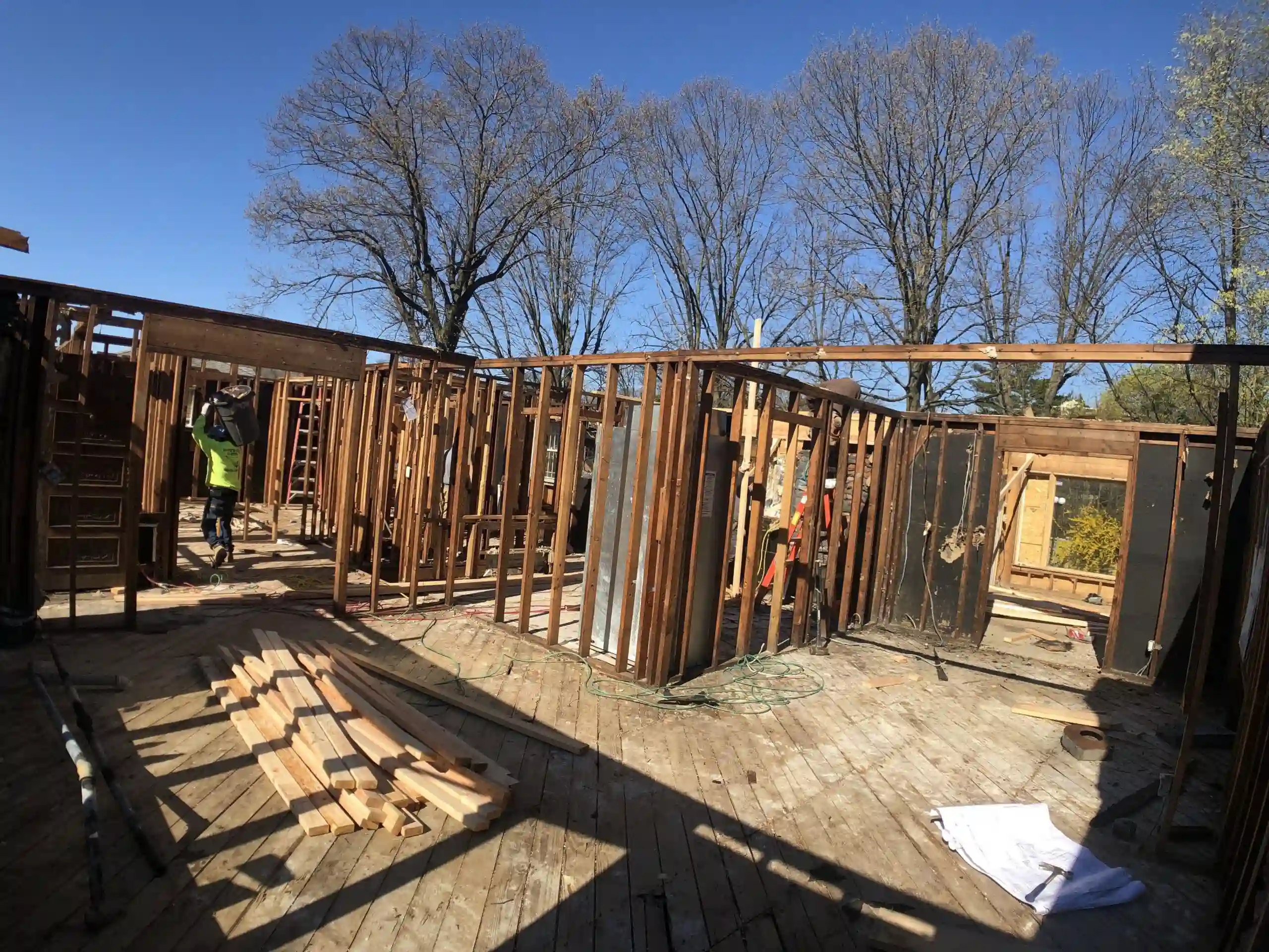 This in-progress home renovation showcases the early stages of construction, with framing and structural work underway. The exposed wooden framework and open floor plan highlight the transformation of the space as it moves toward a fully remodeled home.