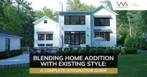 Modern two-story home addition with black windows, white siding, landscaped yard, and classic front entry.
