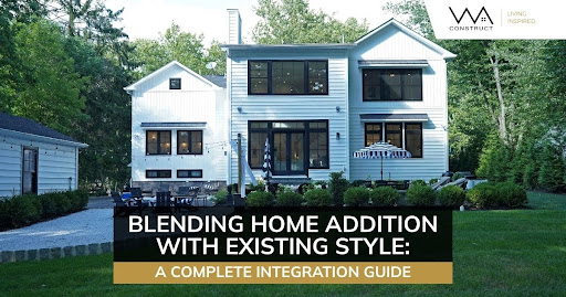 Modern two-story home addition with black windows, white siding, landscaped yard, and classic front entry.