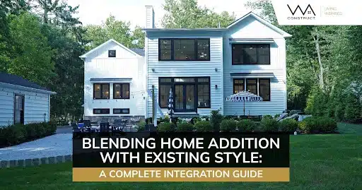 Modern two-story home addition with black windows, white siding, landscaped yard, and classic front entry.