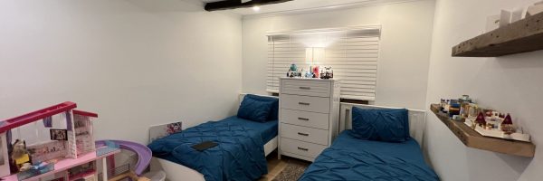 A child's bedroom with twin beds and blue blankets