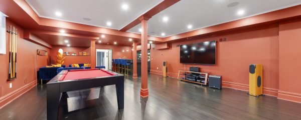 Entertainment room with bold red colors, a pool table, a big screen TV, and a mini-bar